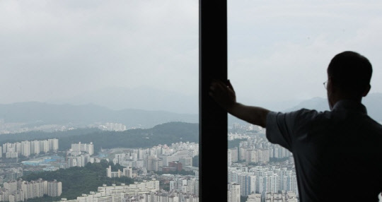 한 시민이 서울 여의도 63스카이아트에서 동작구 일대 아파트 단지를 바라보고 있다.<연합뉴스>